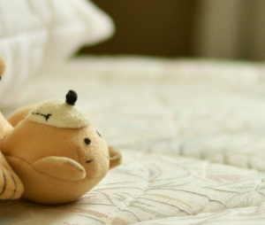 Clean mattress with a teddy bear lying on it